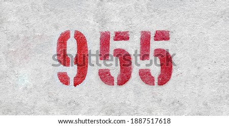 Red Number 955 on the white wall. Spray paint.