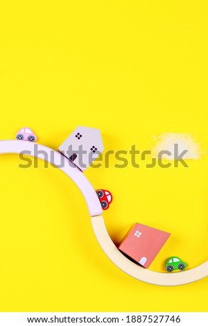 Kid toys background with wooden houses and colorful cars