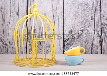 colored cups on table over wooden background