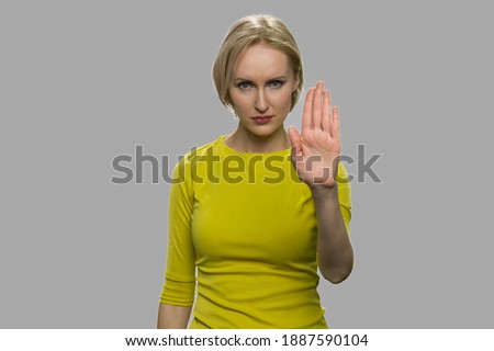 Young confident woman showing stop hand gesture. Prohibition symbol. Do not say a word.