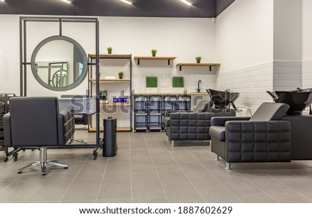 Premium coworking center for hair masters: workplace of the hairdresser with illuminated mirrors and comfortable chairs. Concept of contemporary interior design for hairdresser. Horizontal orientation Royalty-Free Stock Photo #1887602629