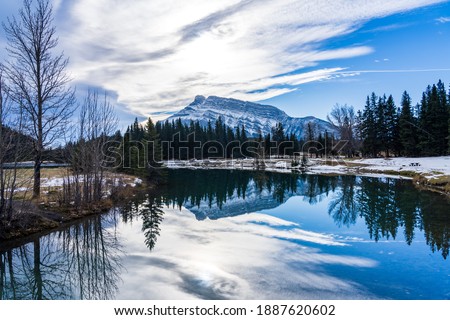 Cascade Ponds park in autumn sunny day, snow-covered Mount Rundle reflection on the water surface. Banff National Park, Canadian Rockies, Alberta, Canada.