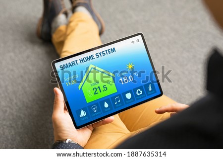 Man controlling home's appliances remotely by using smart home app on tablet computer