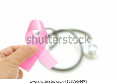 woman holding in hands pink breast cancer sign on white background and stethoscope. cancer day concept.