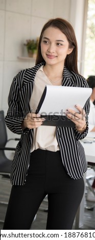 The image of an Asian businessman is a beautiful young woman. Standing with the clipboard and smiling happily