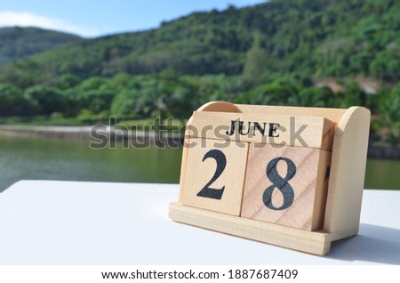 June 28, Date design with number cube on white table, cover design in natural concept.