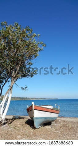 Greek fisherman boat on the beach with sea view on the horizon