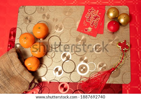 Chinese new year decoration red table, tablecloths and tangerines ancient Chinese coins from  Qing period,Translation "Emperor Shùn Zhì Tōng Bǎo" and red envelopes translation "Good fortune and money”