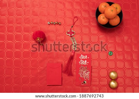 Chinese new year decoration red table, tablecloths, tangerines,  ancient Chinese coins from  Qing period, Translation "Emperor Shùn Zhì Tōng Bǎo" and red envelopes translation "Good fortune and money”