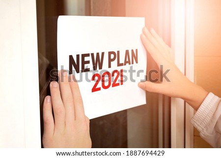 Closeup of owner holding text NEW PLAN 2021 in store