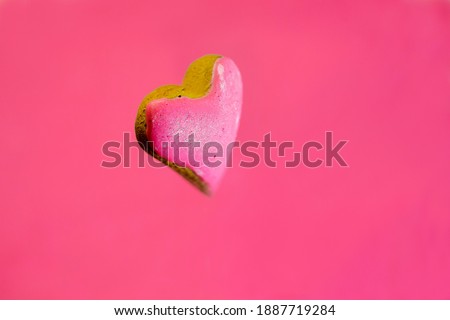 Heart-shaped sweet cookie. Arranged on a pink background.