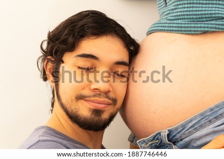 Couple enjoying pregnancy showing their love on a white background