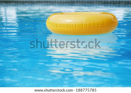 floating ring on blue water swimpool with waves reflecting in the summer sun Royalty-Free Stock Photo #188775785