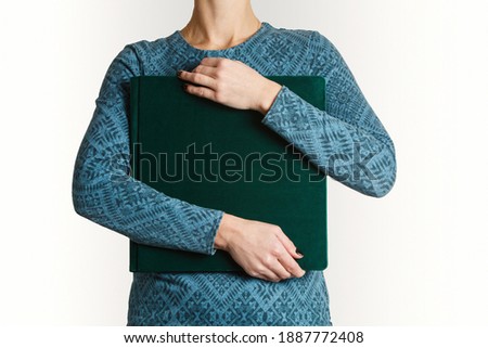 woman hold square family photobook with print with space for text.
sample green family photo album in womans hands with suede cover. wedding photoalbum with leather cover isolated on white background.