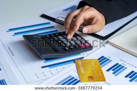 Businessmen use a calculator to calculate income and expenses in order to manage budgets to pay off credit card debt. Royalty-Free Stock Photo #1887779254
