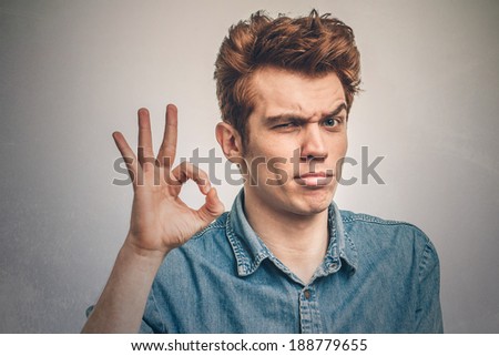 Portrait of a young man showing ok sign