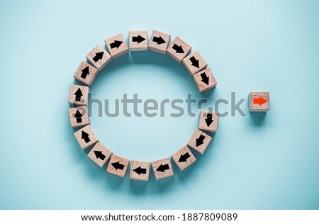 Disruption and technology transformation concept , Red arrow on wooden block cube move out from circle black arrow on blue background. Royalty-Free Stock Photo #1887809089