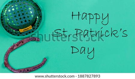 St Patricks day Irish good luck horse shoe and elf hat on a bright green paper background with copy space and text message