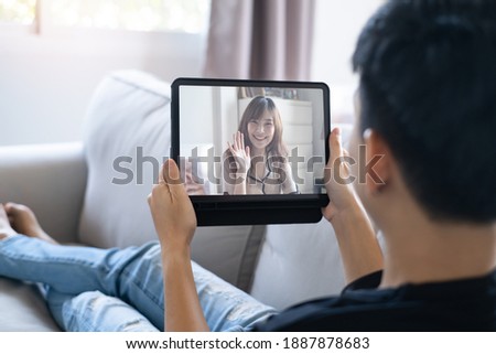 Couple stay at home in different place and using tablet video calling together from far away.They are happy and smile. Valentine's day not together concept.  Royalty-Free Stock Photo #1887878683