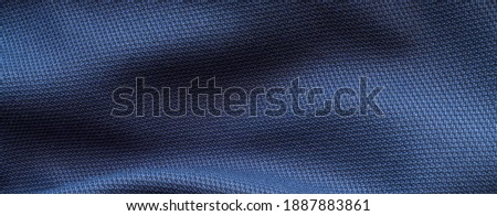 High resolution with details, banner shot of formal dark blue wool suit fabric texture. with button decoration under light and shadow ambient. Ideal for background or wallpaper.
