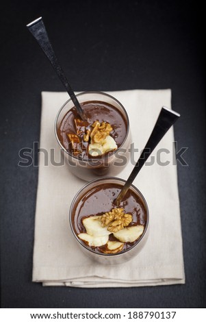 thick hot chocolate in a glass with walnuts and bananas. perfect dessert