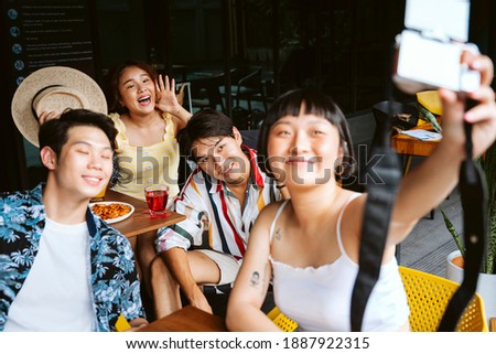 Asian friends taking picture together in summer party.