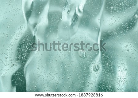 The transparent texture of the face skin care gel. Green natural liquid serum close-up. Cosmetic beauty product with acids and hyaluronic acid. Natural hydration with aloe vera Royalty-Free Stock Photo #1887928816