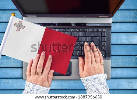 woman hands and flag of Malta on computer, laptop keyboard  Royalty-Free Stock Photo #1887956650