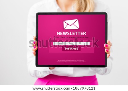 Woman showing tablet with newsletter signup page
