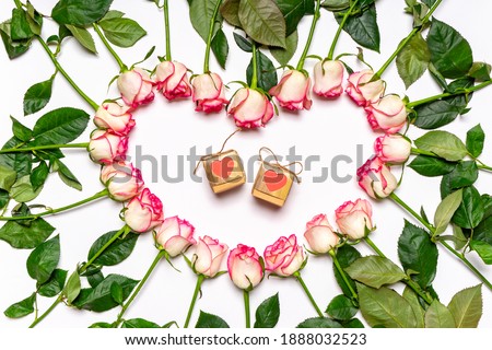 Heart made of beautiful fresh pink roses flowers and gift boxes on white background. Greeting card, happy Valentine's day concept. Love, romance, wedding. Flat lay, top view