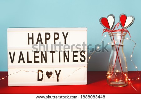 Happy Valentines day lightbox with a couple of heart decorations. 14 February greeting card