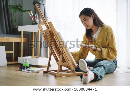 Female Artist painting on canvas at home. Hobby and leisure concept.
