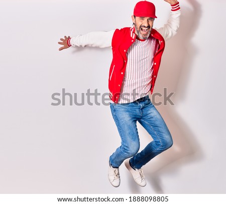 Middle age handsome man wearing baseball uniform smiling happy. Jumping with smile on face over isolated white background