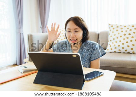 Asian woman aged 30-35 years using tablet, watching lesson Sign language online course communicate by conference video call from home, e-learning education concept
