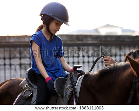 Asian shool kid girl with horse ,riding or practicing horse ridding at horse ranch.