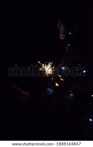 Christmas banner with copy space. Burning sparkler with bokeh light background. Sparks of sparkler on background of New Year's lights. Christmas eve.