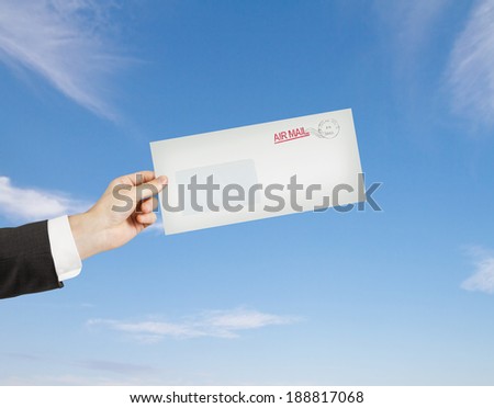 hand giving a envelope on sky background