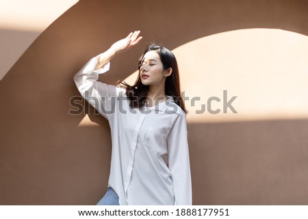 Portrait of a beautiful Asian woman with healthy skin. She uses a sun protection hand that hits her face to protect against UV that has caused her face to dull. Royalty-Free Stock Photo #1888177951