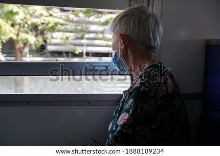 Selective focus, senior Asian woman sitting in train and wears face mask for safe travel and prevent spreading covid-19 for public health. Concept of safe travels, health care, face mask.