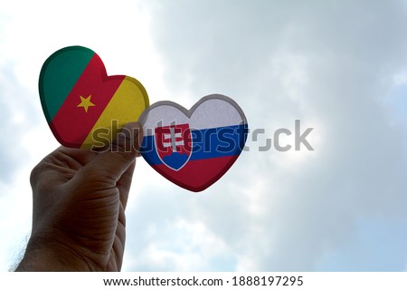Hand holds a heart Shape Cameroon and Slovakia flag, love between two countries