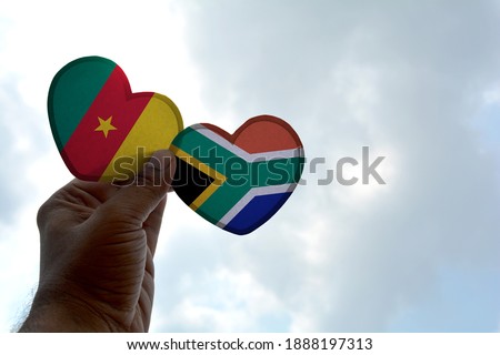 Hand holds a heart Shape Cameroon and South Africa flag, love between two countries