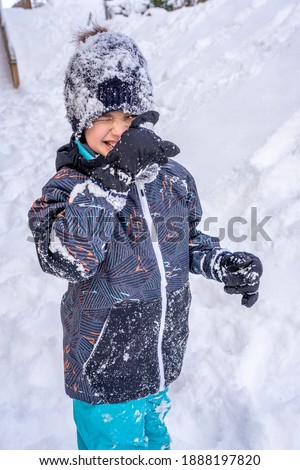 Boy playing in the snow. Cold snowy winter. Happy childhood. High quality photo