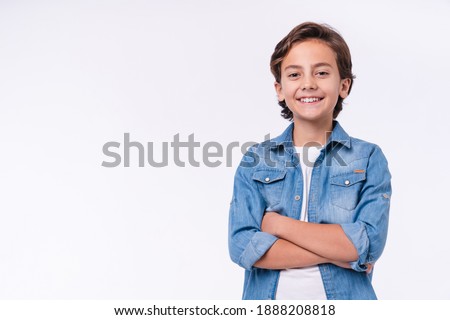 Happy young caucasian boy in casual outfit with arms crossed isolated over white background Royalty-Free Stock Photo #1888208818