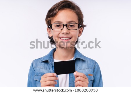 Close up photo of young white boy holding credit card isolated over white background