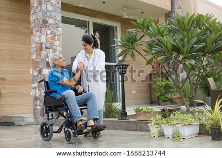 Female nurse assisting a senior man in a wheelchair