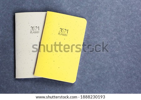 Yellow and grey 2021 planner on grey coloured background. 