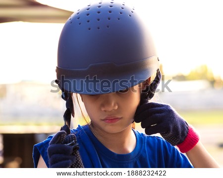 Asian shool kid girl with horse ,riding or practicing horse ridding at horse ranch.