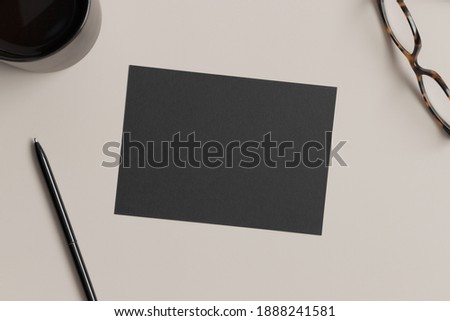 Invitation black card mockup with workspace accessories. 5x7 ratio, similar to A6, A5.