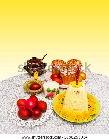 easter composition with cakes and painted eggs with a yellow chicken in a nest on a table on a yellow and white background with a copy space