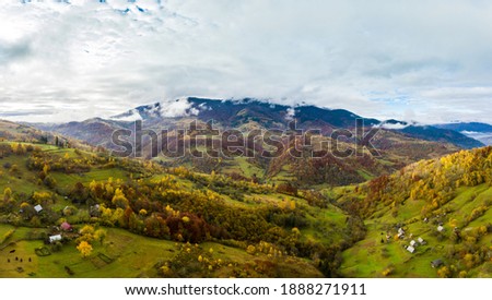 Sky with white and fluffy layer of clouds over green autumn hills, Aerial panoramic drone shot
